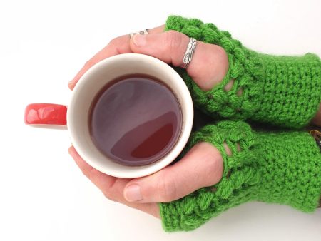 green cozy & warm crocheted mittens - in use - cup