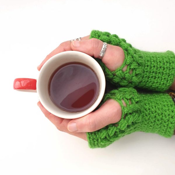green cozy & warm crocheted mittens - in use - cup